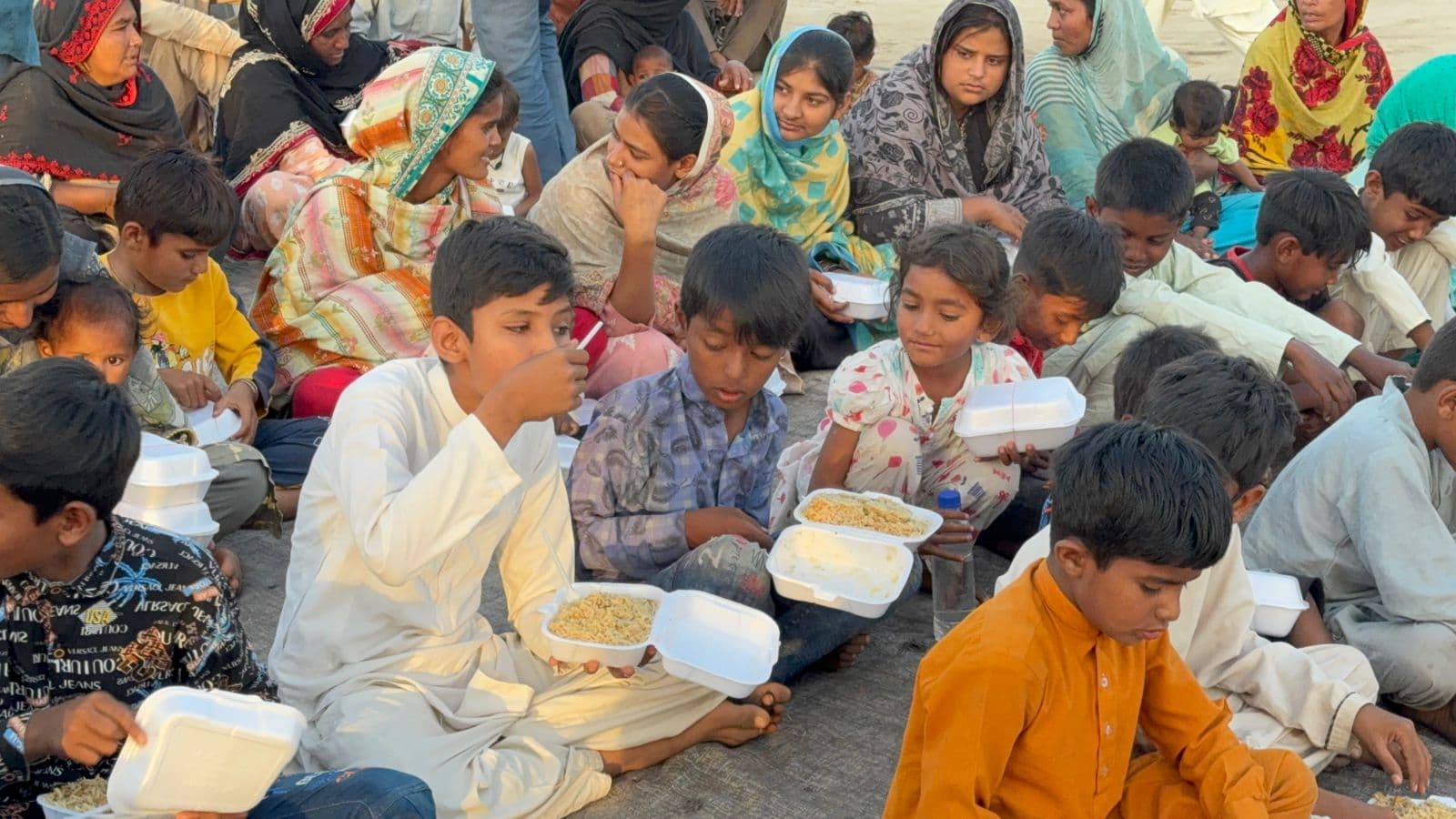 Children sitting together during a meal at a brick kiln outreach gathering