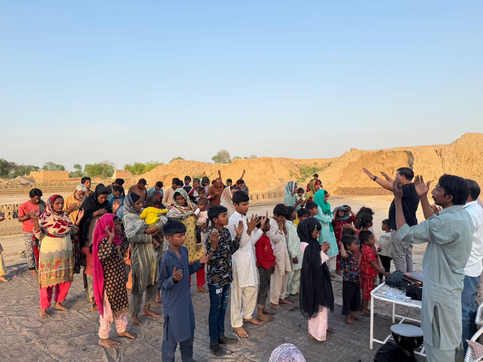 Children and families gathered at a brick kiln community site